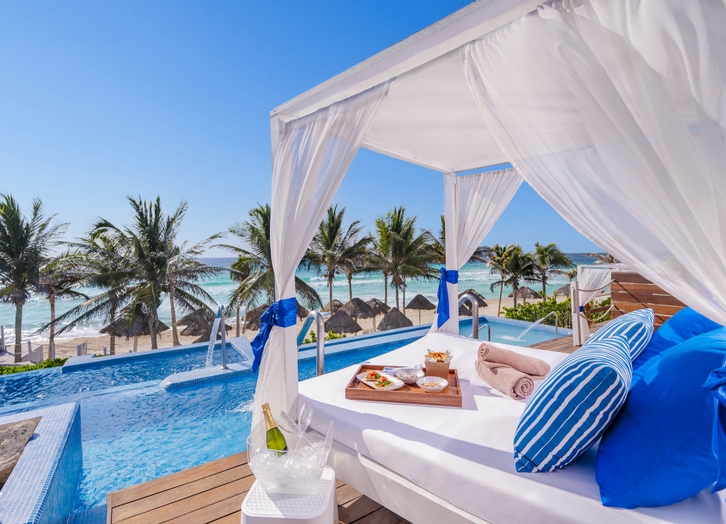 Balinese daybed with snacks and champagne facing the pool and sea at The Pyramid Cancun