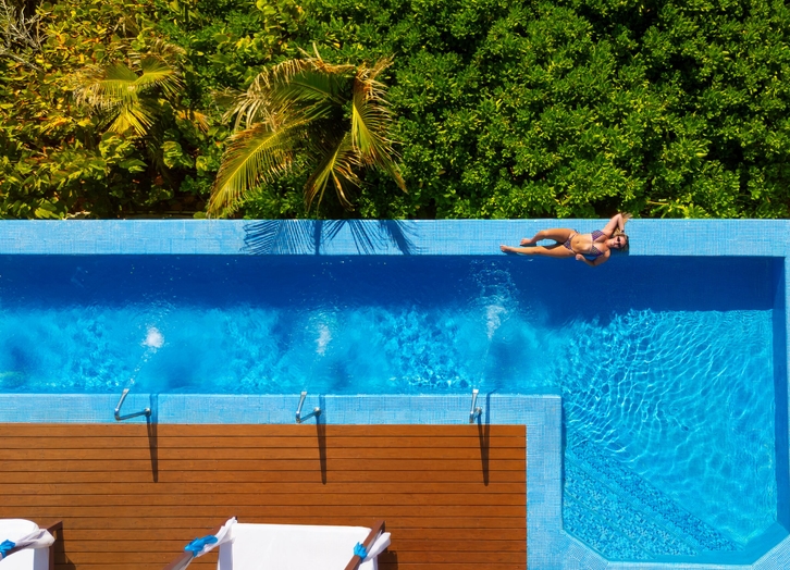 Woman sunbathing at the edge of the pool at The Pyramid Cancun hotel
