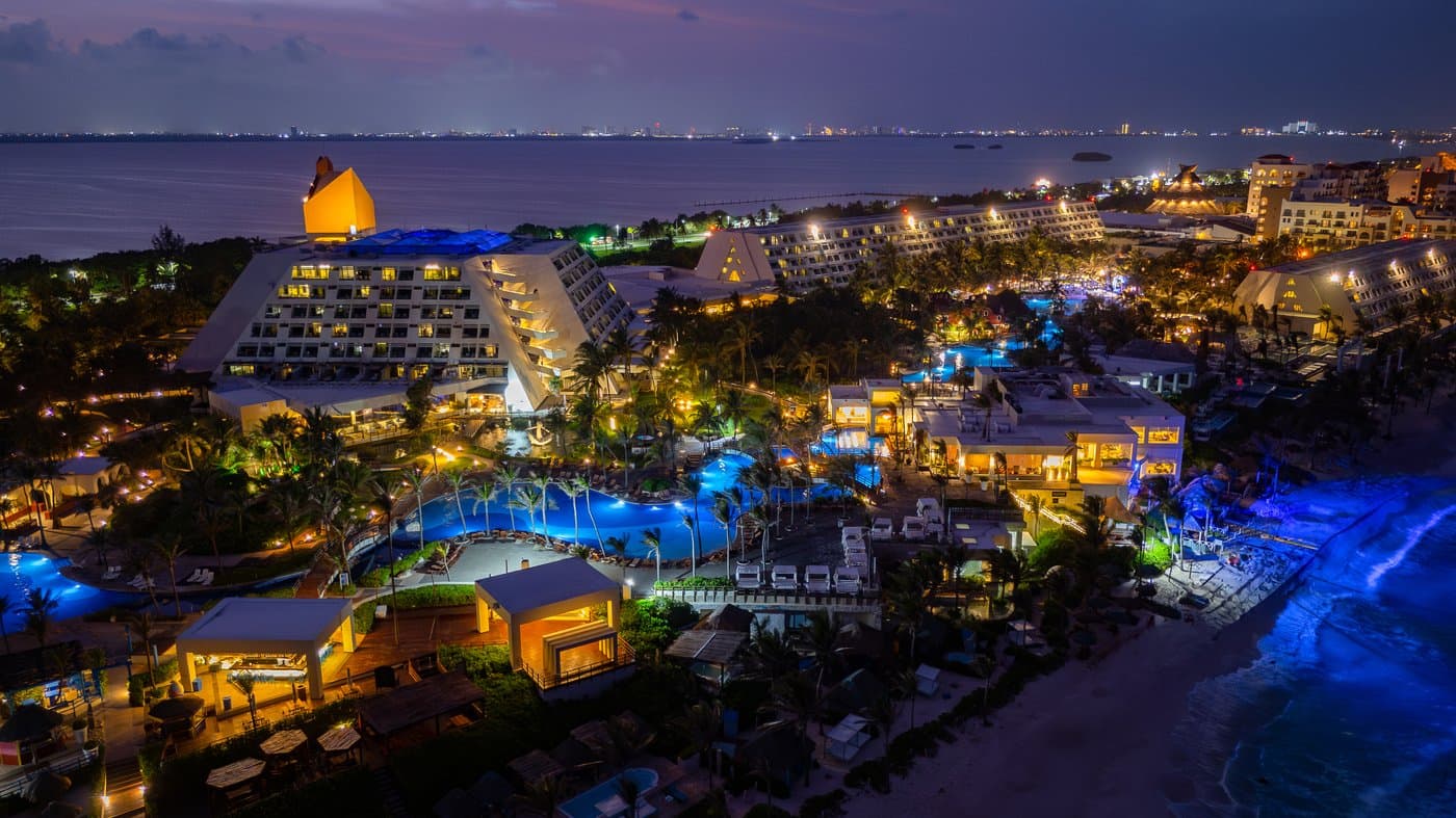 Panoramic night view of the hotel The Pyramid Cancun and the pool areas.